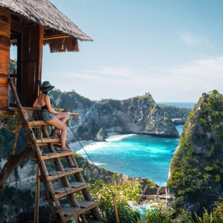 Wooden staircase leading to a cliffside beach in Nusa Penida, Bali with turquoise waters